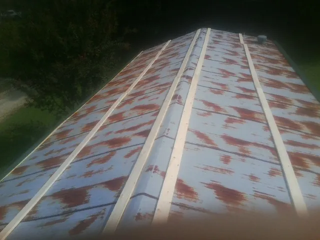 Rusted metal roof panels with new wood purlins before replacement — Storm Damage Roof Repair in Jacksonboro by Roofing Brothers
