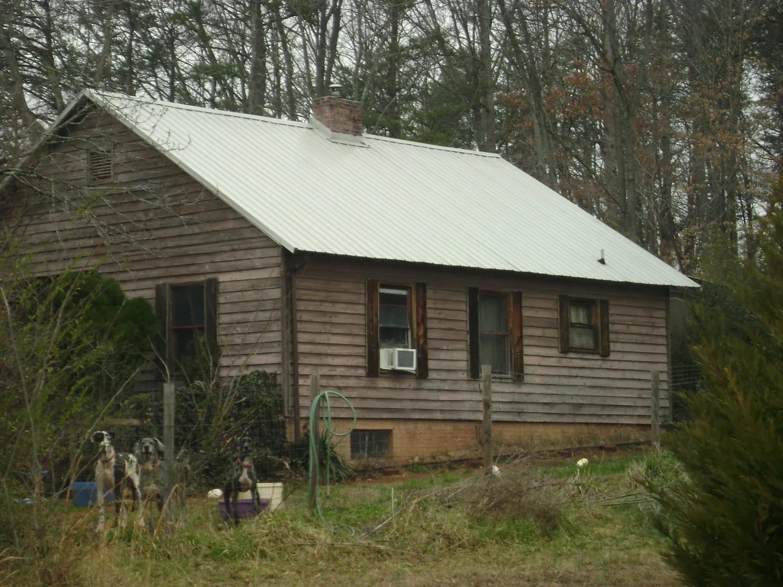 White metal roof on an old wood sided farmhouse, from a Metal Roof Installation job in Jacksonboro